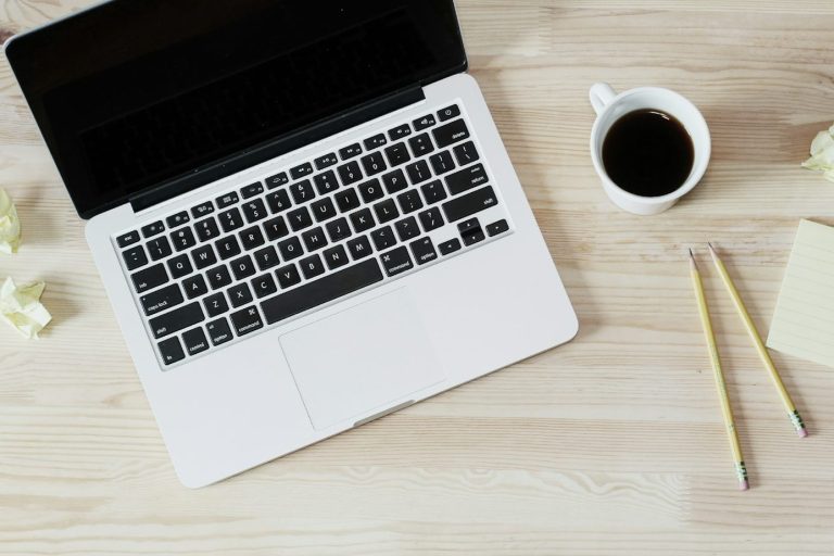 Bird's eye view of a laptop next to a cup of coffee